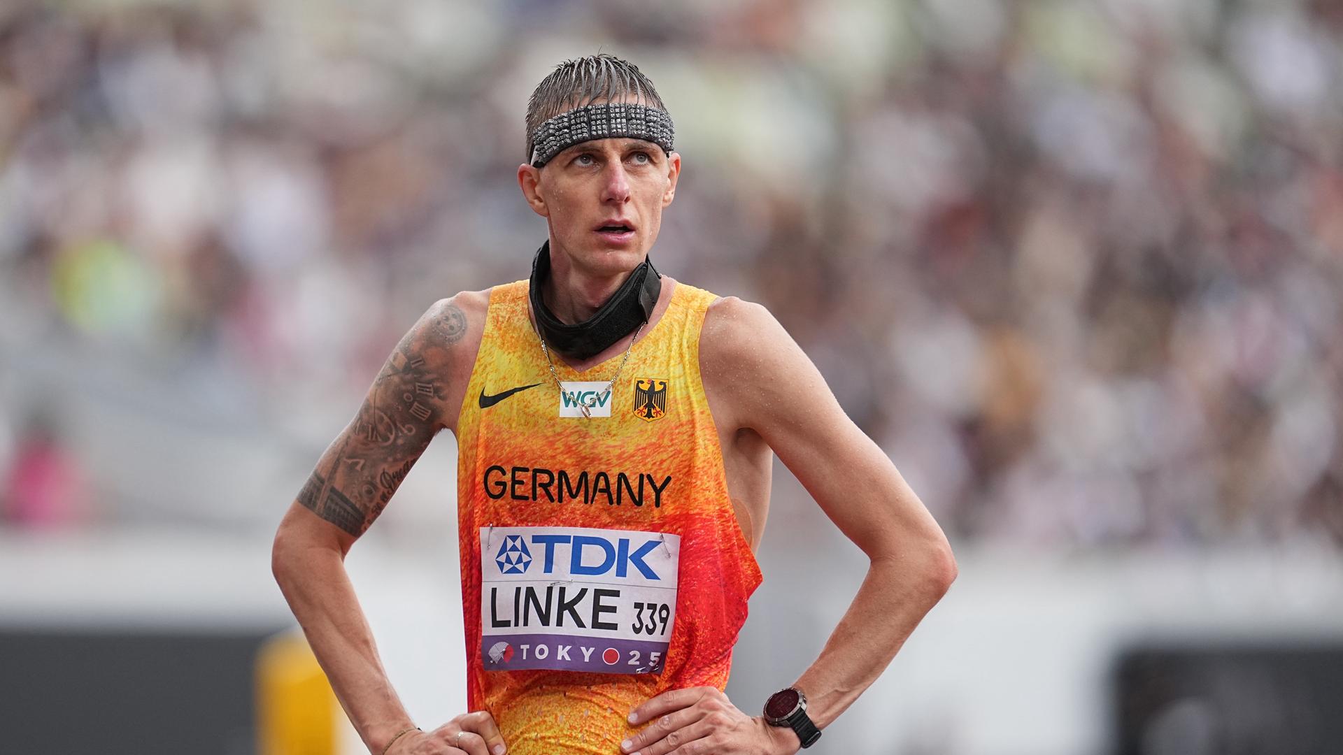 Ein Mann im Leichtathletik-Trikot schau erschöpft und enttäuscht. Ein Mann im Leichtathletik-Trikot schau erschöpft und enttäuscht.