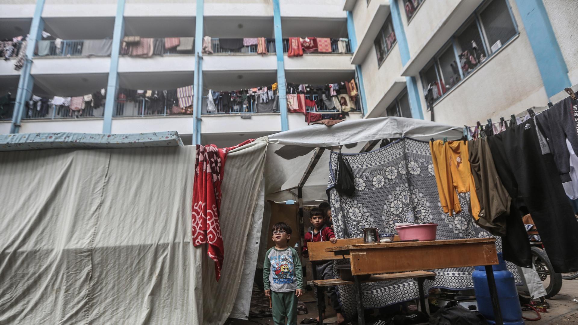 Zwei Kinder unter einer Plane in einer von der UN zur Verfügung gestellten Flüchtlingsunterkunft im Süden des Gazastreifens. 