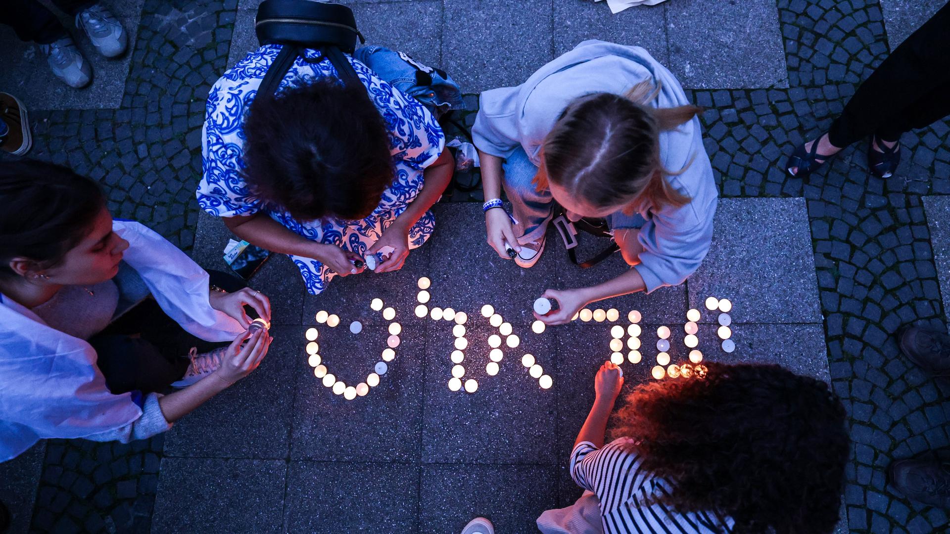 Bei einer Kundgebung gegen Antisemitismus und Terror - entzünden Teilnehmende Kerzen und drücken ihre Solidarität aus.