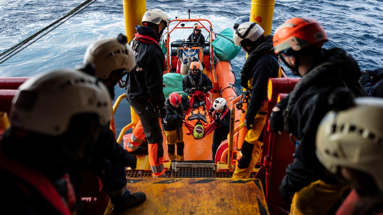 Die Besatzung eines Bootes der Seenotrettung bei einer Übung. Eine Puppe wird aus einem Rettungsboot auf das Hauptboot umgesetzt.