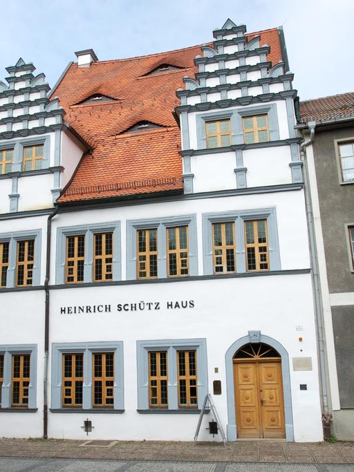 Blick auf das weiß-graue Heinrich Schütz Haus, das mit seinen besonderen Fassadenaufbauten punktet.