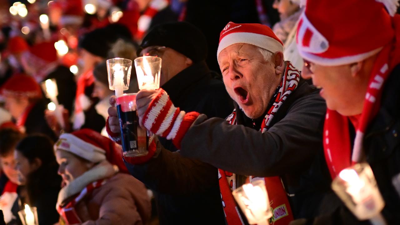 Weihnachtssingen im Stadion von Union Berlin. Ein Mann mit einer Nikolausmütze singt lauthals mit. 