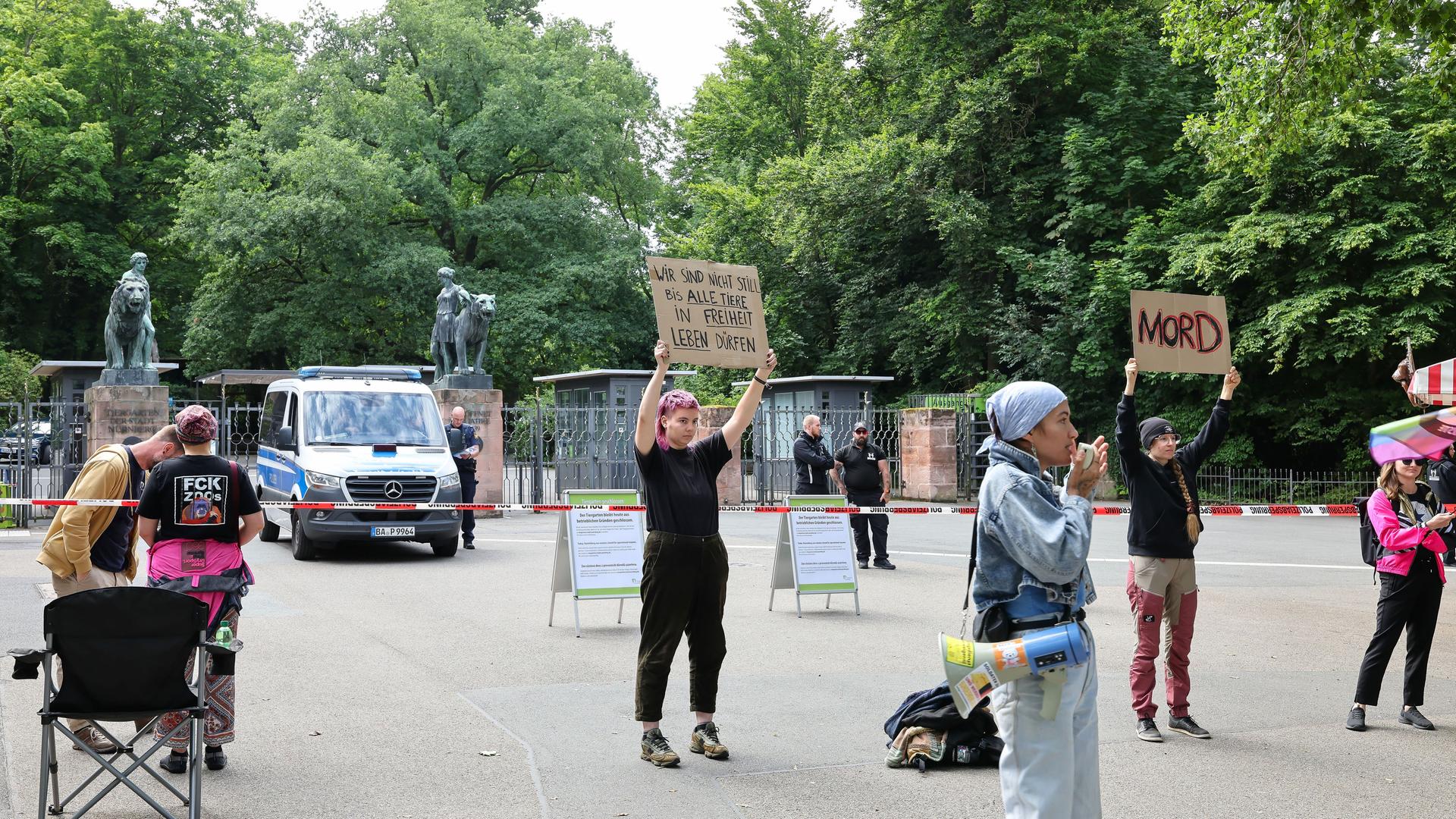 Animal Rebellion und vereinzelte Demonstranten anderer Gruppierungen stehen mit Protestschildern vor dem Tiergarten Nürnberg. 