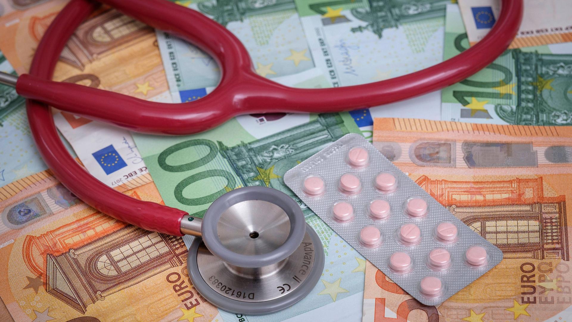 Das Bild zeigt ein Stethoskop, das auf mehreren Euro-Scheinen liegt.