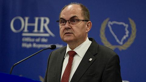 Der CSU-Politiker Christian Schmidt ist Hoher Repräsentant der internationalen Gemeinschaft in Bosnien-Herzegowina. Er steht an einem Redepult, im Hintergrund das Emblem OHR für sein Amt. 