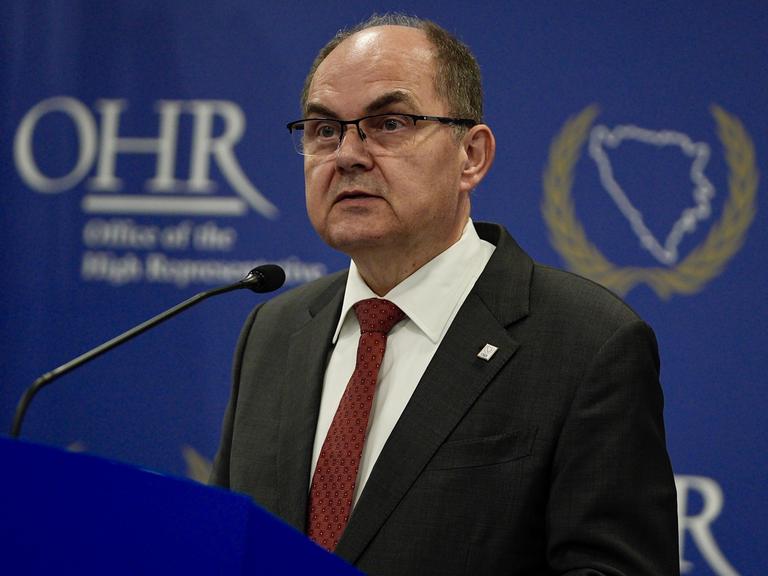 Der CSU-Politiker Christian Schmidt ist Hoher Repräsentant der internationalen Gemeinschaft in Bosnien-Herzegowina. Er steht an einem Redepult, im Hintergrund das Emblem OHR für sein Amt. 