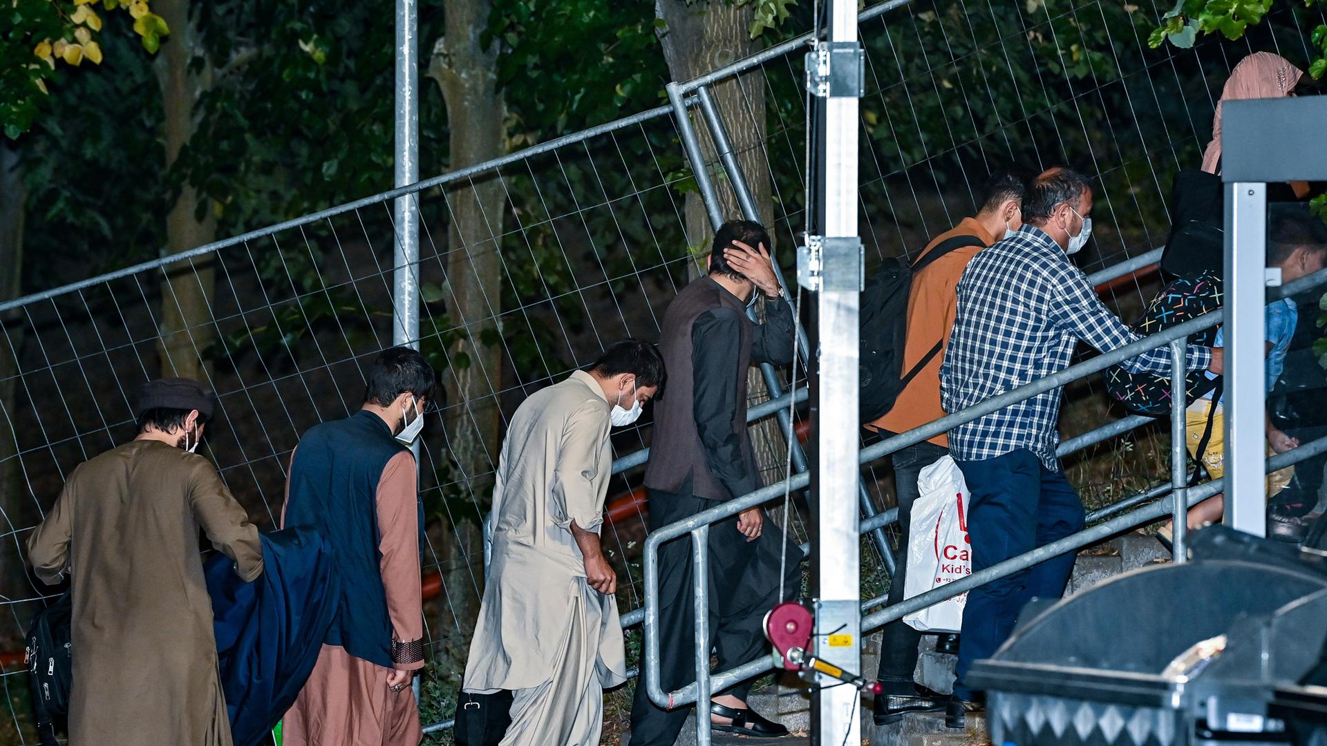 Ortskräfte aus Afghanistan gehen am frühen Morgen auf dem Gelände der DRK-Flüchtlingshilfe in der Erstaufnahmeeinrichtung zu ihrer Unterkunft in Brandenburg.