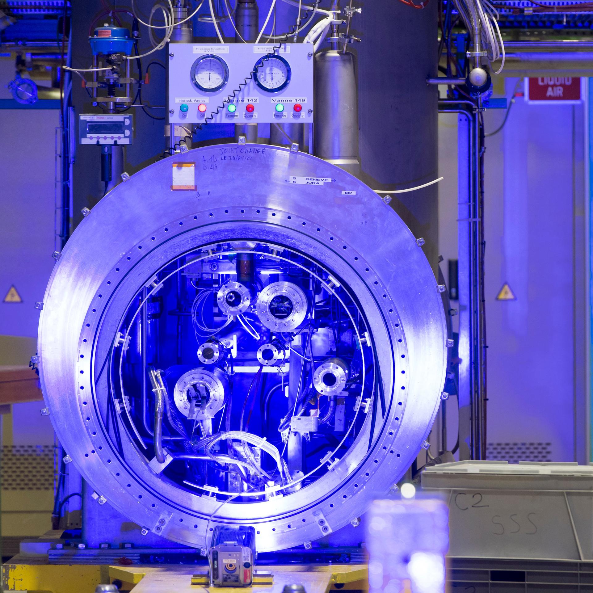 Im Forschungszentrum CERN wird ein kompliziertes technisches Gerät blau ausgeleuchtet.