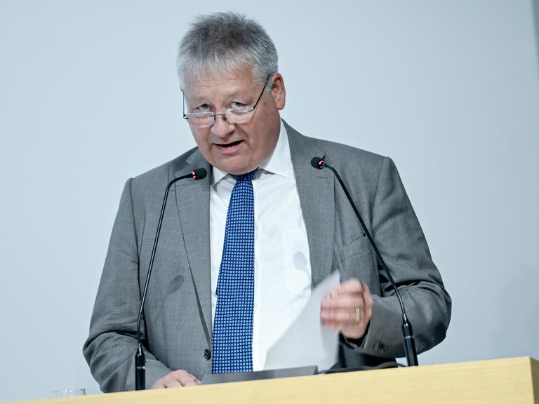 Bruno Kahl, BND-Präsident spricht bei der Eröffnung der Erweiterung des BND-Besucherzentrums. Er steht an einem Rednerpult mit zwei Mikrofonen und hält ein Blatt Papier in der Hand.