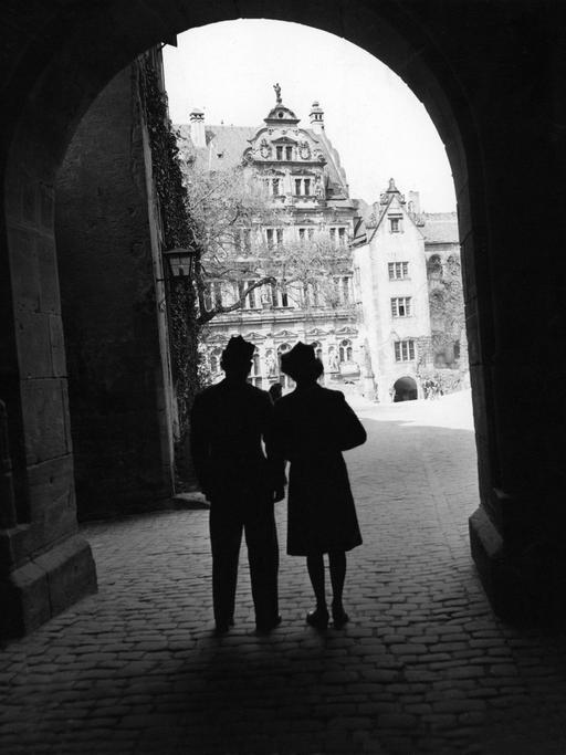 Schwarzweißaufnahme eines Paares, das in einem Torbogen in Heidelberg steht. Er ist Soldat, die Zeit ist Ende des Zweiten Weltkriegs.