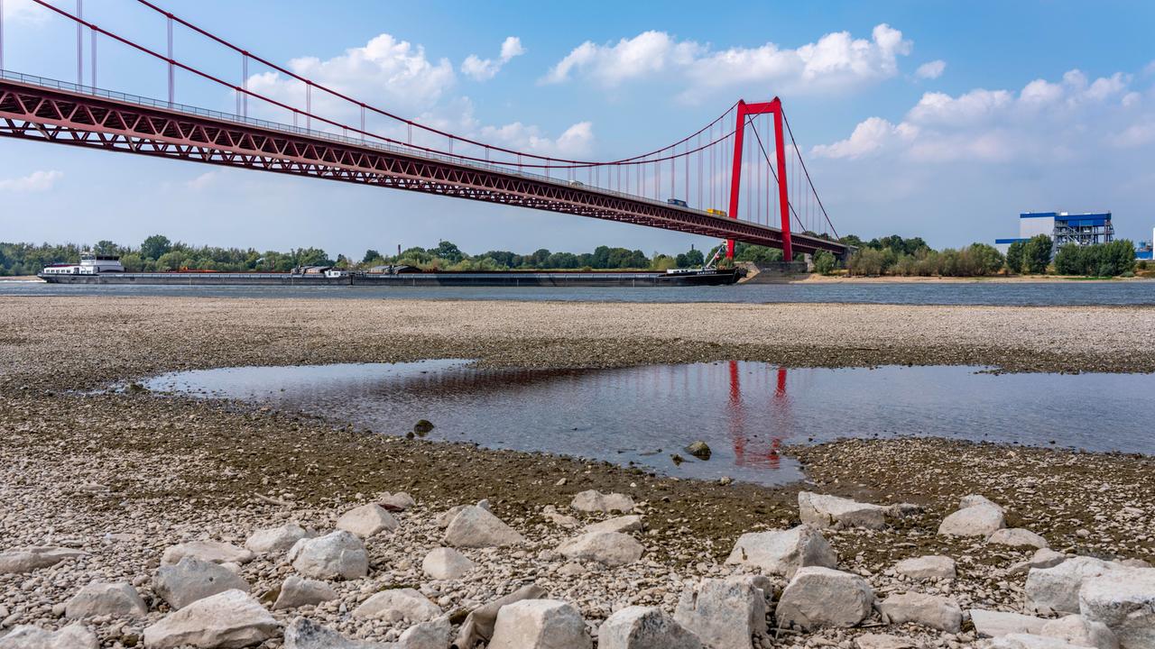 Ansicht einer roten Hängebrücke über den Rhein mit extrem niedrigem Wasserstand. Ansicht einer roten Hängebrücke über den Rhein mit extrem niedrigem Wasserstand.