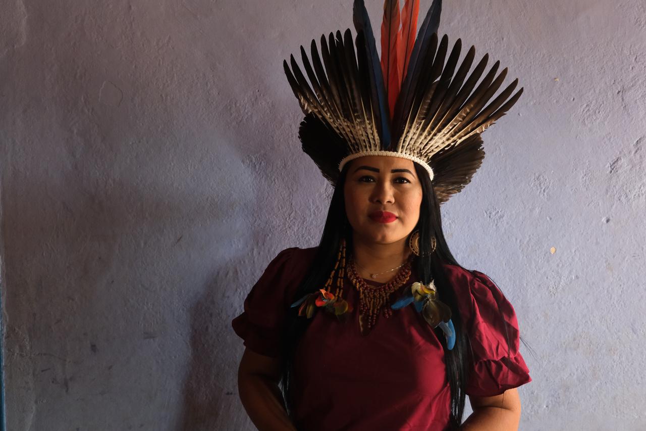 Eine junge indigene Frau aus Brasilien mit Kopfschmuck und roter Bluse