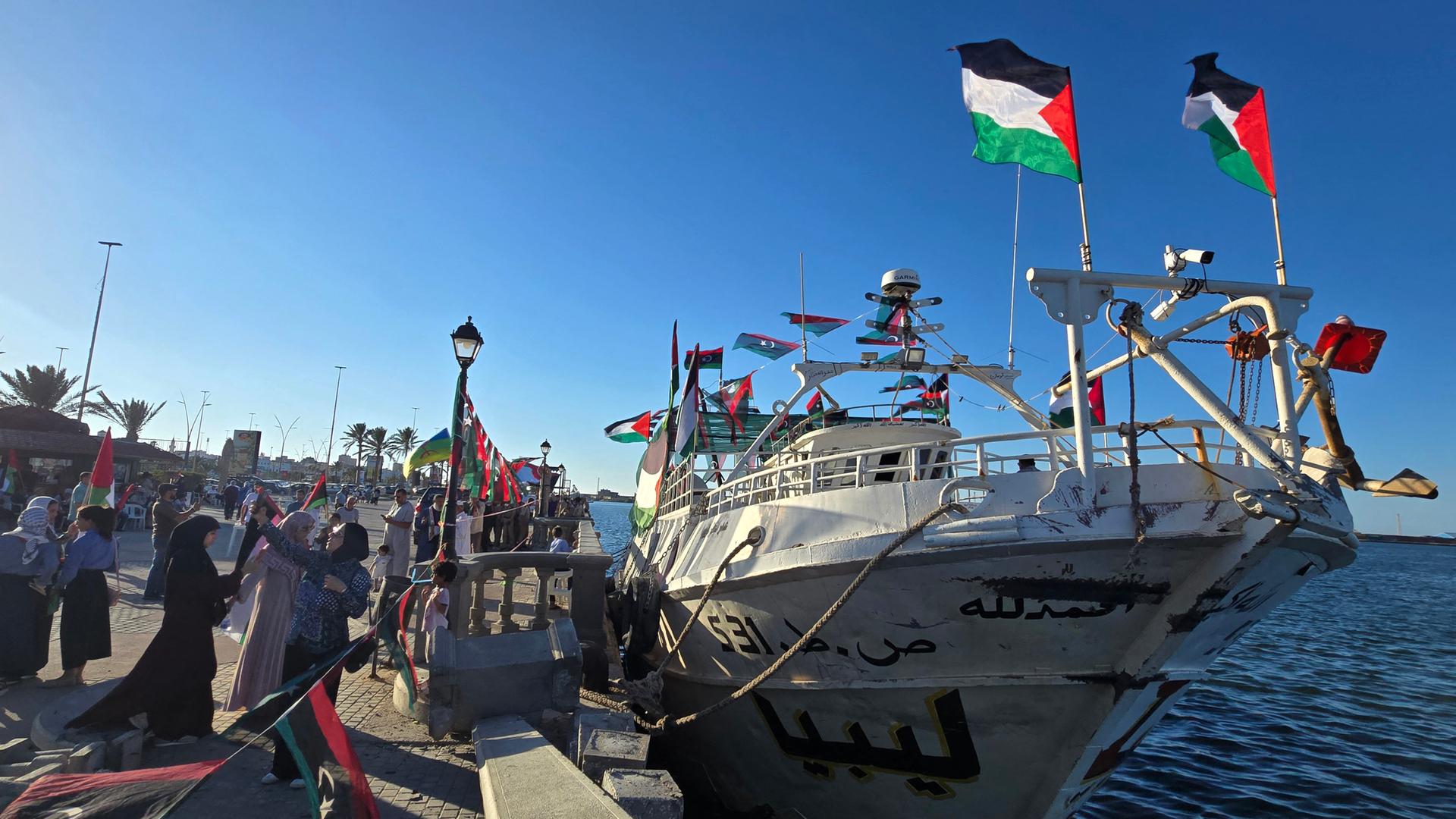 Menschen posieren für ein Foto vor dem Schiff „Omar al-Mukhtar“, einem libyschen Schiff.