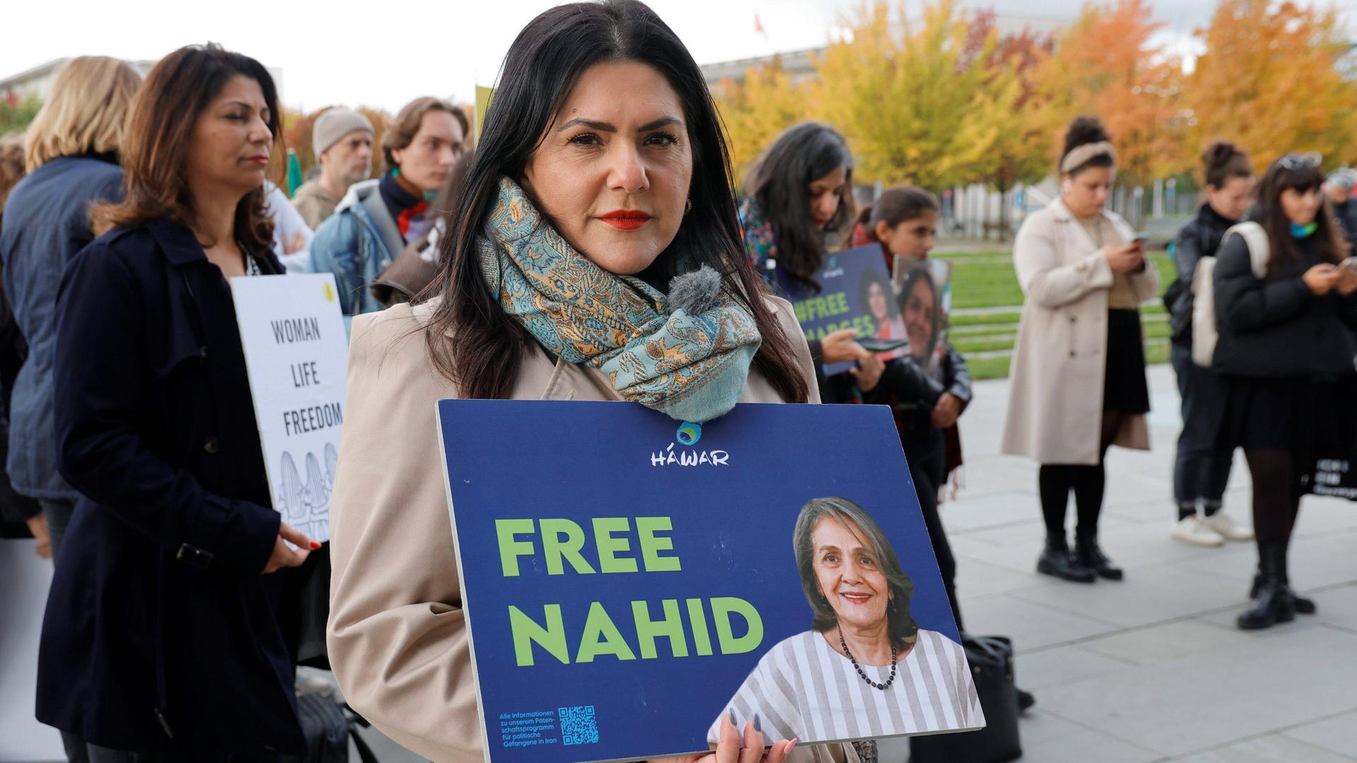 Mariam Claren hält ein Schild mit der Aufschrift "Free Nahid" und einem Foto von Nahid Taghavi vor sich.