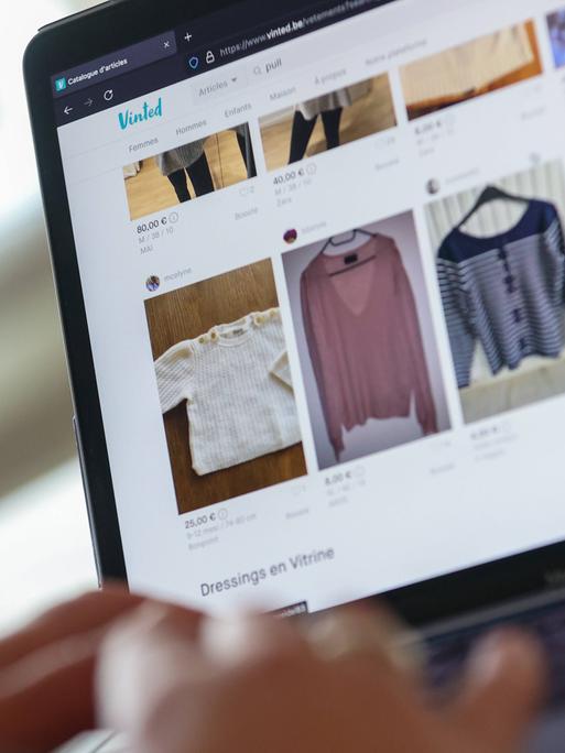 Auf einem Laptop ist die Secondhand-Plattform Vinted geöffnet. Zu sehen sind mehrere Anzeigen mit gebrauchten Kleidungsstücken, die Nutzerinnen und Nutzer über die Plattform kaufen und verkaufen können.