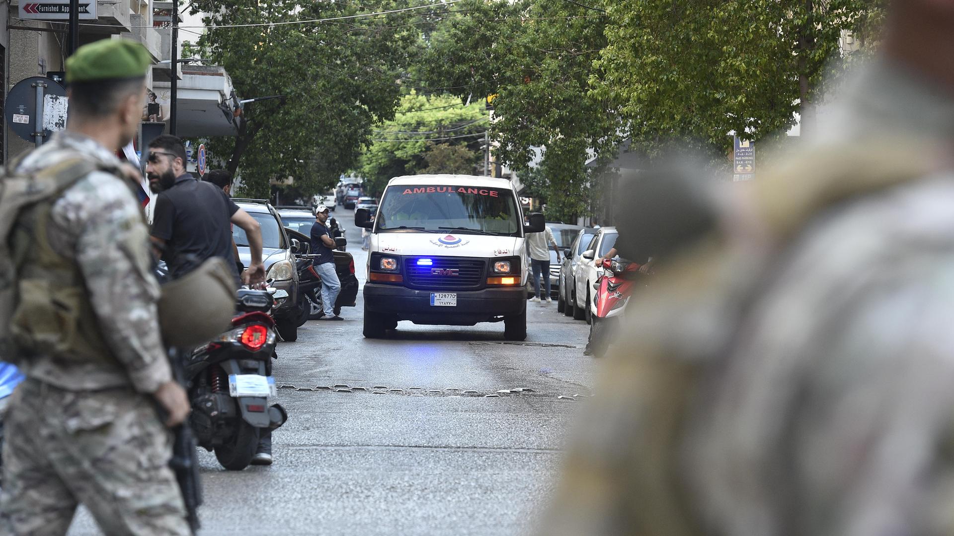 In Beirut, im Libanon, fährt ein Krankenwagen eine Straße entlang. Im Vordergrund stehen zwei Soldaten (17. September 2024)