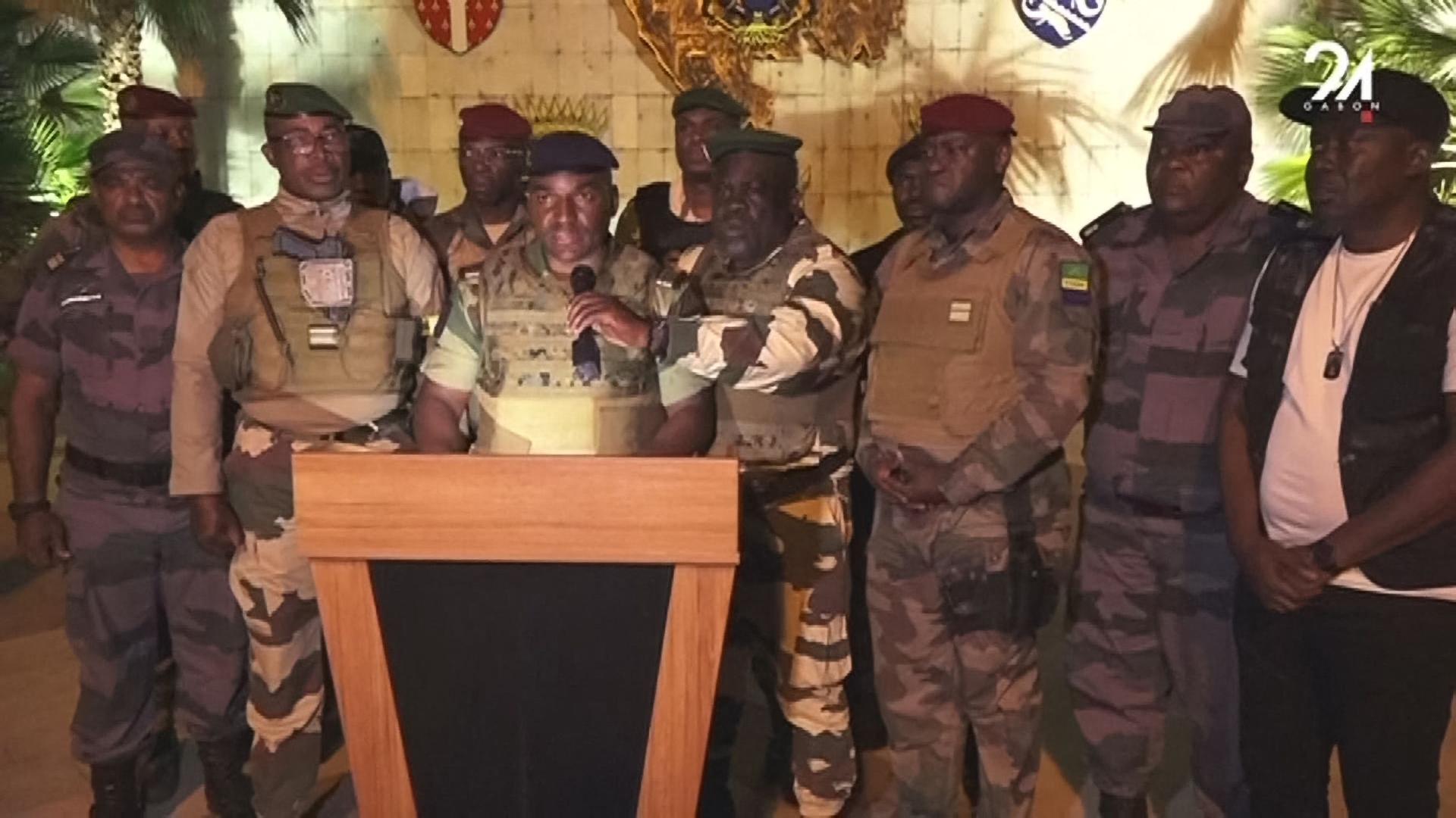 Zentralafrika, Gabun: Mehrere Soldaten stehen hinter einem Rednerpult, einer von ihnen spricht in ein Mikrofon.