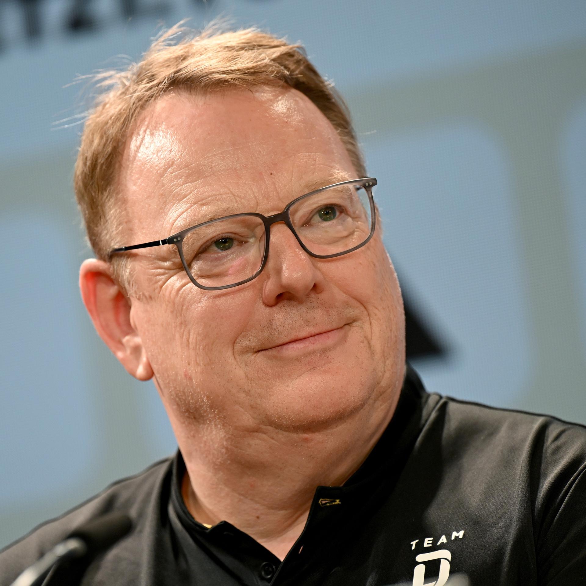 Torsten Burmester, DOSB-Vorstandsvorsitzender, lächelt bei einer Pressekonferenz.