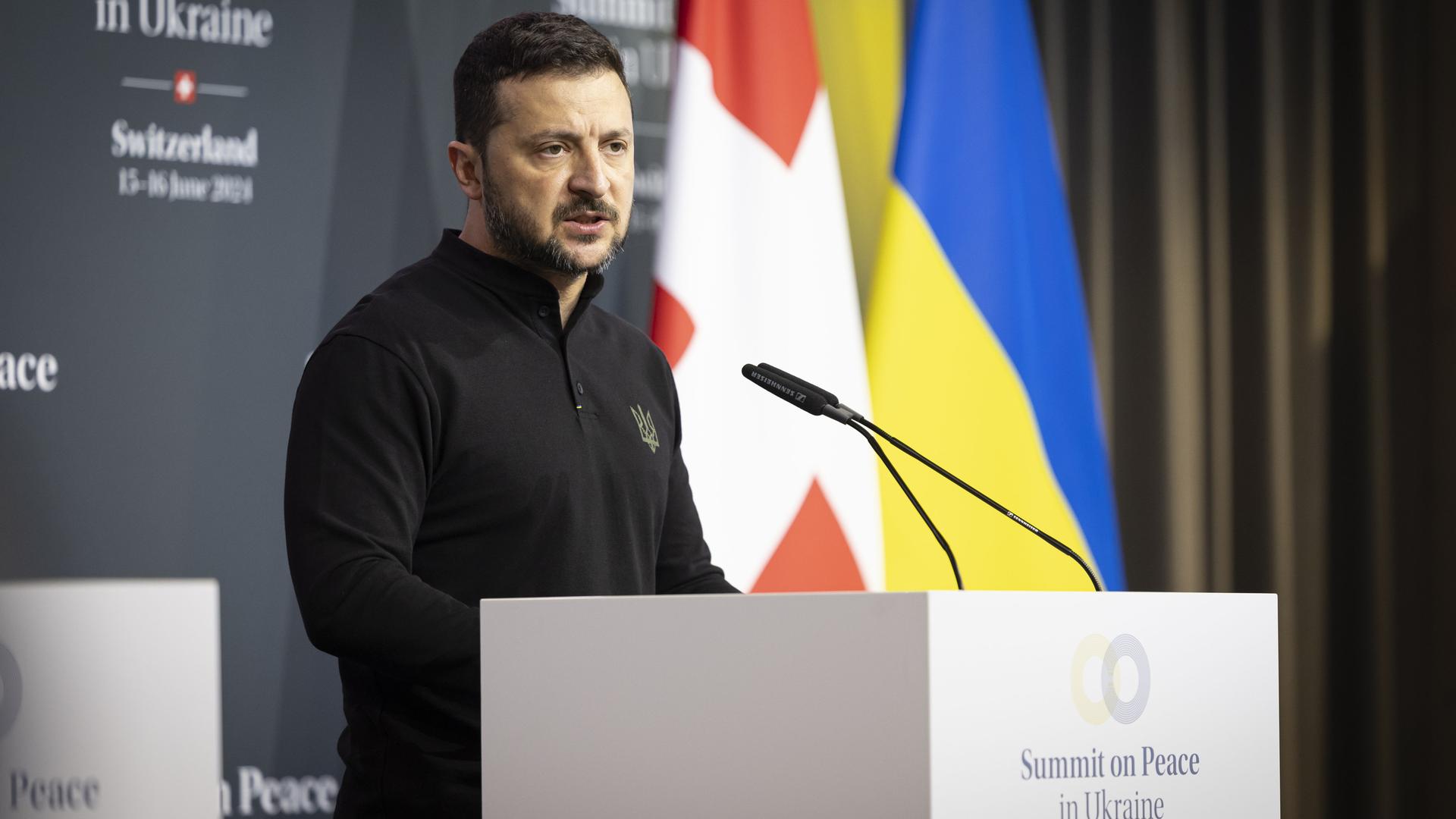 Der ukrainische Präsident Selenskyj steht am Rednerpult, im Hintergrund zu sehen die Flaggen der Schweiz und der Ukraine. Der ukrainische Präsident Selenskyj steht am Rednerpult, im Hintergrund zu sehen die Flaggen der Schweiz und der Ukraine.