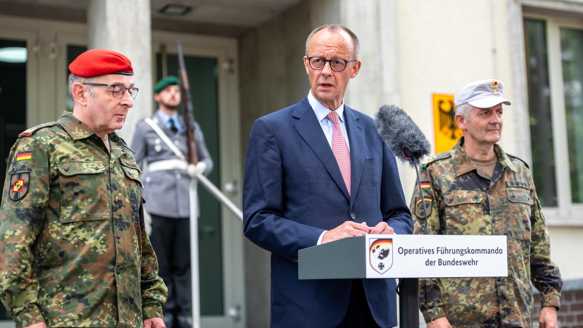 Bundeskanzler Friedrich Merz (CDU) steht am Rednerpult. Rechts neben ihm Alexander Sollfrank, Befehlshaber des Führungskommandos. Links zu sehen ist Carsten Breuer, Generalinspekteur der Bundeswehr. Bundeskanzler Friedrich Merz (CDU) steht am Rednerpult. Rechts neben ihm Alexander Sollfrank, Befehlshaber des Führungskommandos. Links zu sehen ist Carsten Breuer, Generalinspekteur der Bundeswehr.
