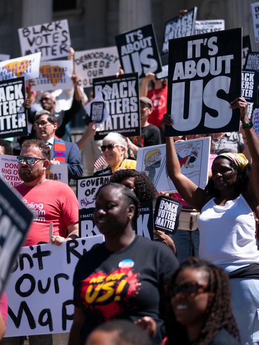 Demonstranten halten während einer Kundgebung gegen die Neuaufteilung der Kongresswahlbezirke Schilder in die Höhe. Auf den Schilder steht "Black Voters Matter".