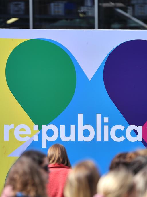 Besucher am ersten Tag vor einem Logo der Digitalmesse Republica