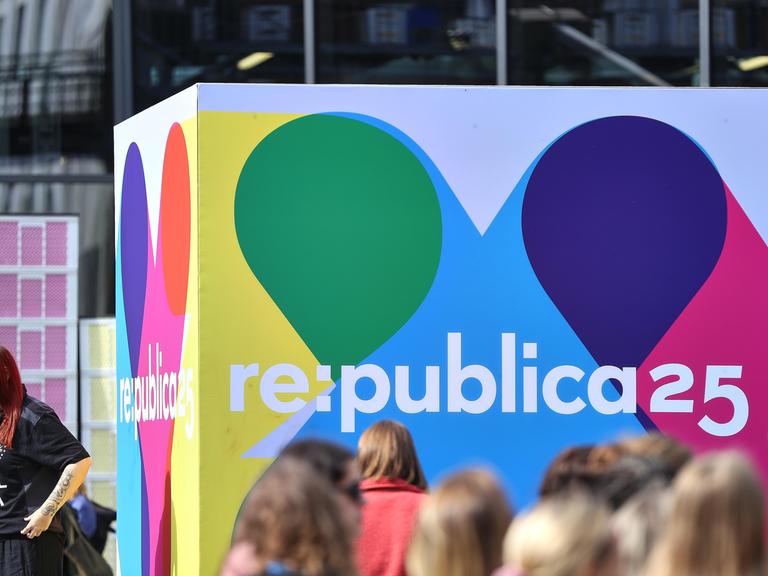  Besucher am ersten Tag vor einem Logo der Digitalmesse Republica