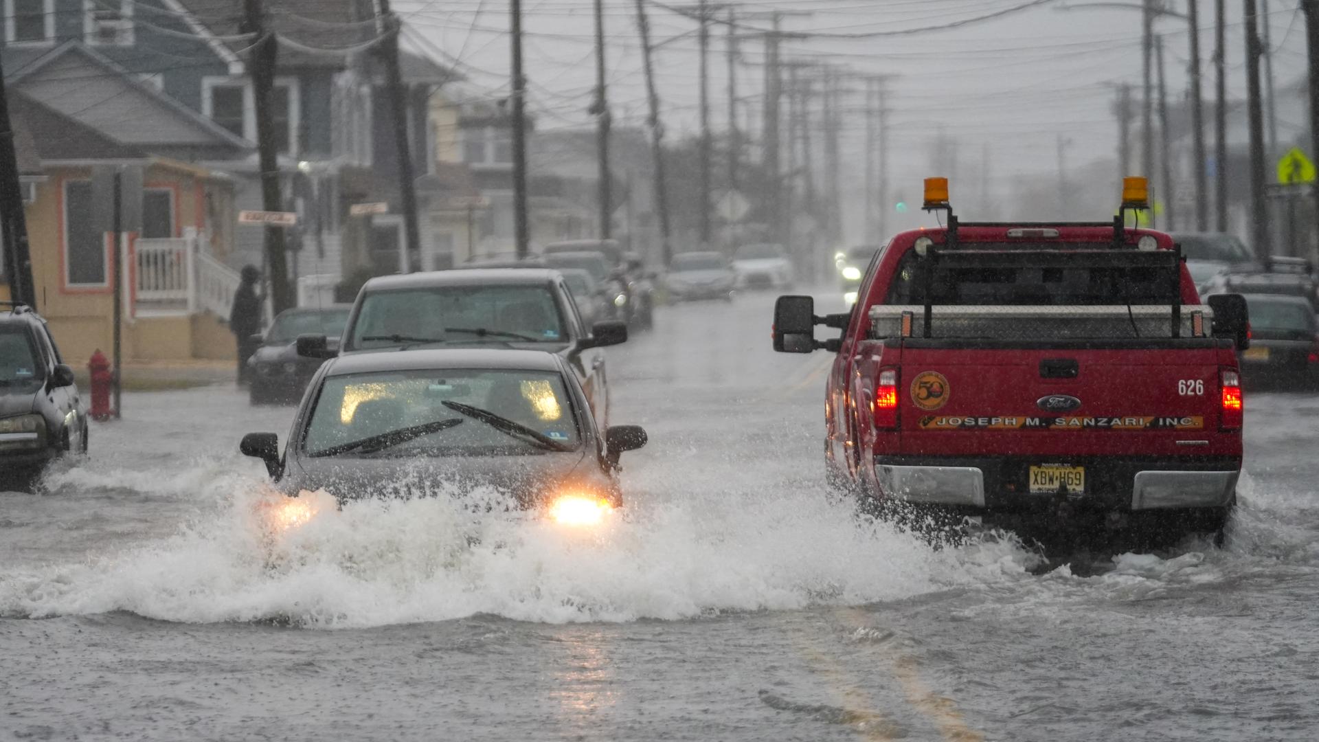 Sturm in den USA: Das Foto zeigt Autos, die durch eine überflutete Straße fahren. Sturm in den USA: Das Foto zeigt Autos, die durch eine überflutete Straße fahren.