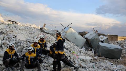 Weiß Helme, Mitglieder des Zivilschutzes in den syrischen Rebellengebieten, machen eine Pause von Rettungsarbeiten in der Stadt Sarmada im Gouvernement Idlib nach dem schweren Erdbeben in der Region. 