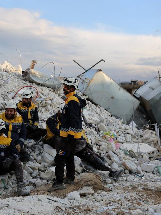 Weiß Helme, Mitglieder des Zivilschutzes in den syrischen Rebellengebieten, machen eine Pause von Rettungsarbeiten in der Stadt Sarmada im Gouvernement Idlib nach dem schweren Erdbeben in der Region. 