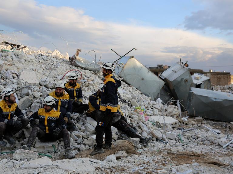 Weiß Helme, Mitglieder des Zivilschutzes in den syrischen Rebellengebieten, machen eine Pause von Rettungsarbeiten in der Stadt Sarmada im Gouvernement Idlib nach dem schweren Erdbeben in der Region. 
