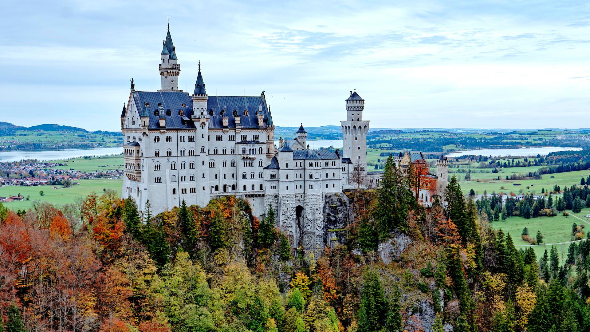 Blick auf Neuschwanstein umgeben von herbstlichen Wäldern Blick auf Neuschwanstein umgeben von herbstlichen Wäldern