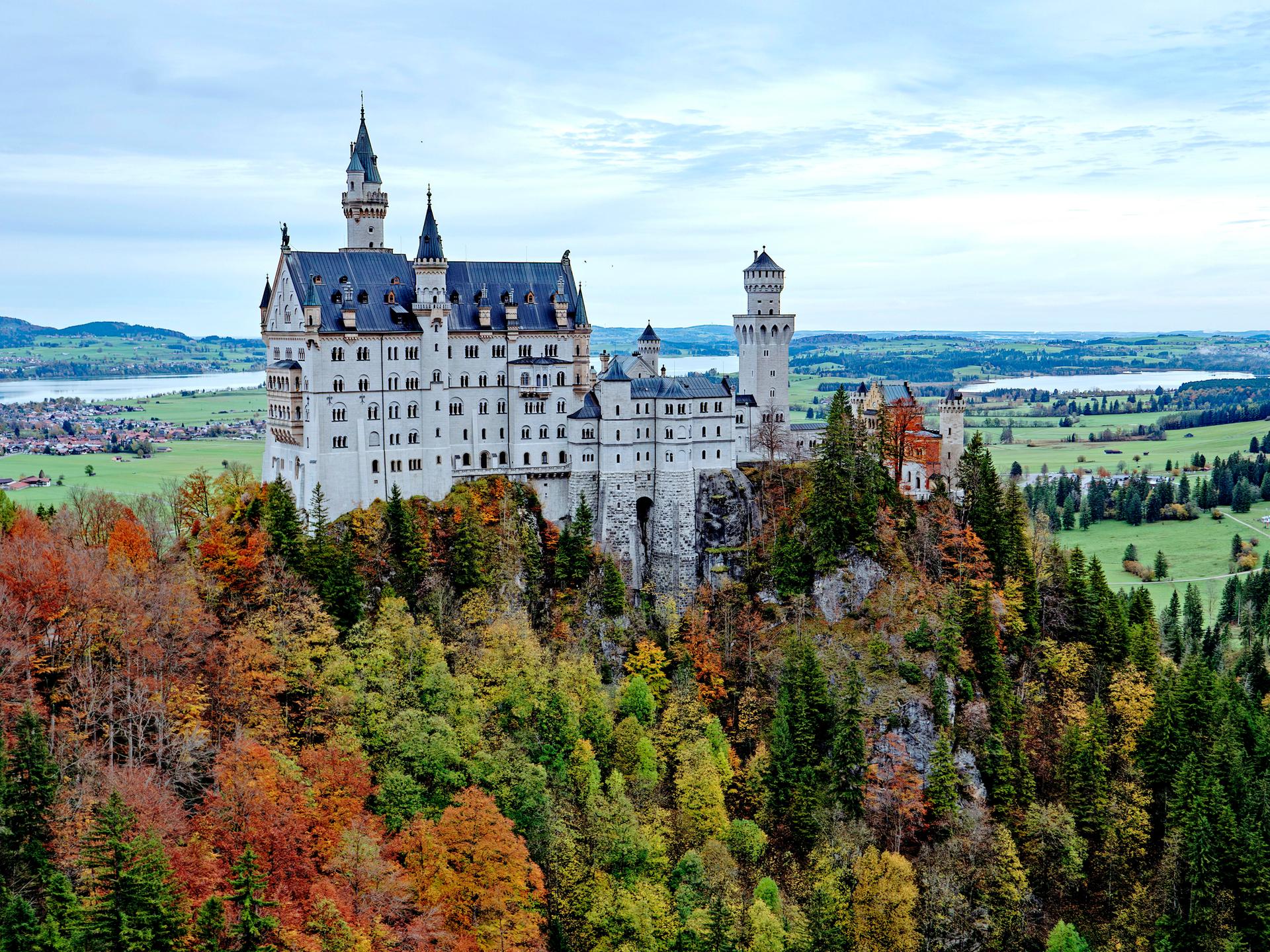 Blick auf Neuschwanstein umgeben von herbstlichen Wäldern