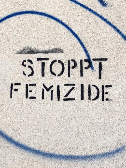 Die Parole "Stoppt Femizide" ist in Großbuchstaben auf eine Wand geschrieben.
