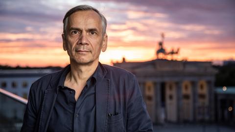 Lutz Seiler steht vor dem Brandenburger Tor in Berlin, 2020.