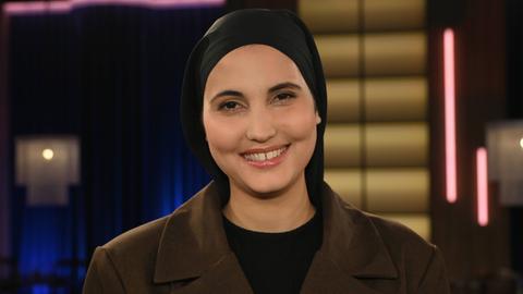 Comedienne Anissa Loucif zu Gast in der WDR Talkshow Kölner Treff. Sie trägt ein dunkles Kopftuch und lacht vergnügt in die Kamera. Comedienne Anissa Loucif zu Gast in der WDR Talkshow Kölner Treff. Sie trägt ein dunkles Kopftuch und lacht vergnügt in die Kamera.