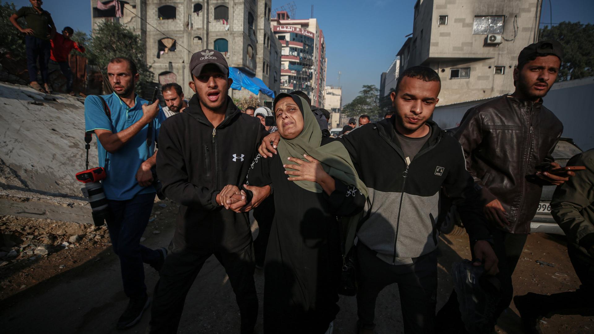 Palästinenser halten einen Trauerzug am Al-Shifa-Krankenhaus ab, sie stützen sich gegenseitig.
