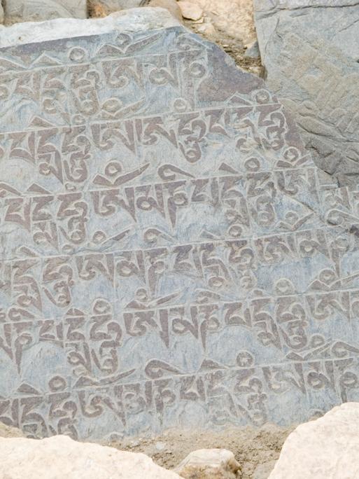 Auf einem Stein ist eine Inschrift in Devanagari-Schrift zu lesen