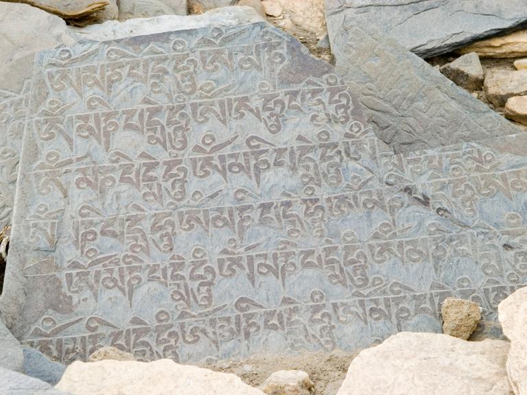 Auf einem Stein ist eine Inschrift in Devanagari-Schrift zu lesen