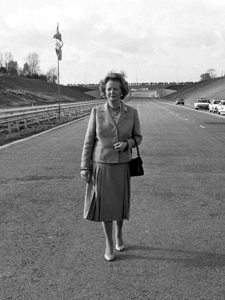 Ein Scharz-Weiß-Foto zeigt die damalige britische Premierministerin Margaret Thatcher nach der offiziellen Eröffnung der Autobahn M25 in Hertfordshire allein auf der Fahrbahn stehend.