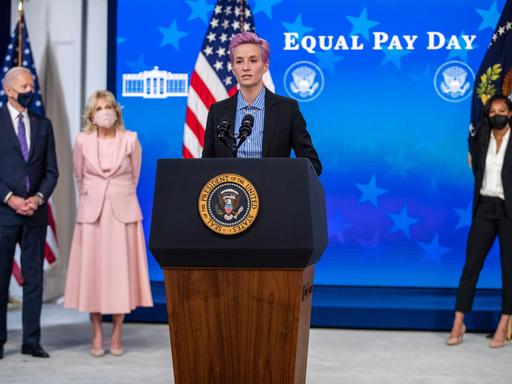 US-Fußballerin Megan Rapinoe am Rednerpult vor US-Präsident Joe Biden und First Lady Jill Biden, im Hintergrund steht "Equal pay day"