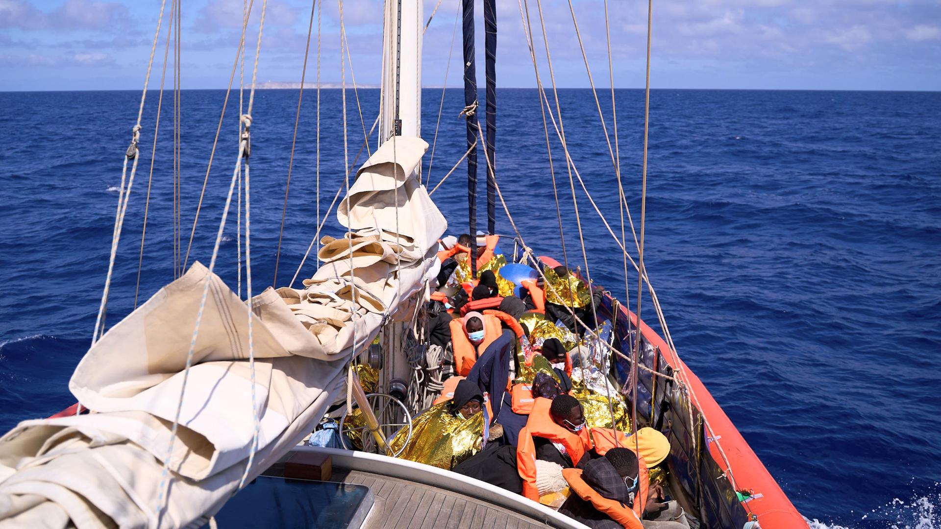 An Bord des Motorsegelschiffs "Nadir" sitzen viele gerettete Migranten. Sie tragen orangene Rettungswesten. An Bord des Motorsegelschiffs "Nadir" sitzen viele gerettete Migranten. Sie tragen orangene Rettungswesten.