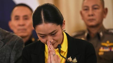 Thailands Ministerpräsidentin Paetongtarn Shinawatra bereitet sich darauf vor, das Regierungsgebäude in Bangkok zu verlassen. Sie hat die Hände vor ihrem Gesicht gefaltet. 