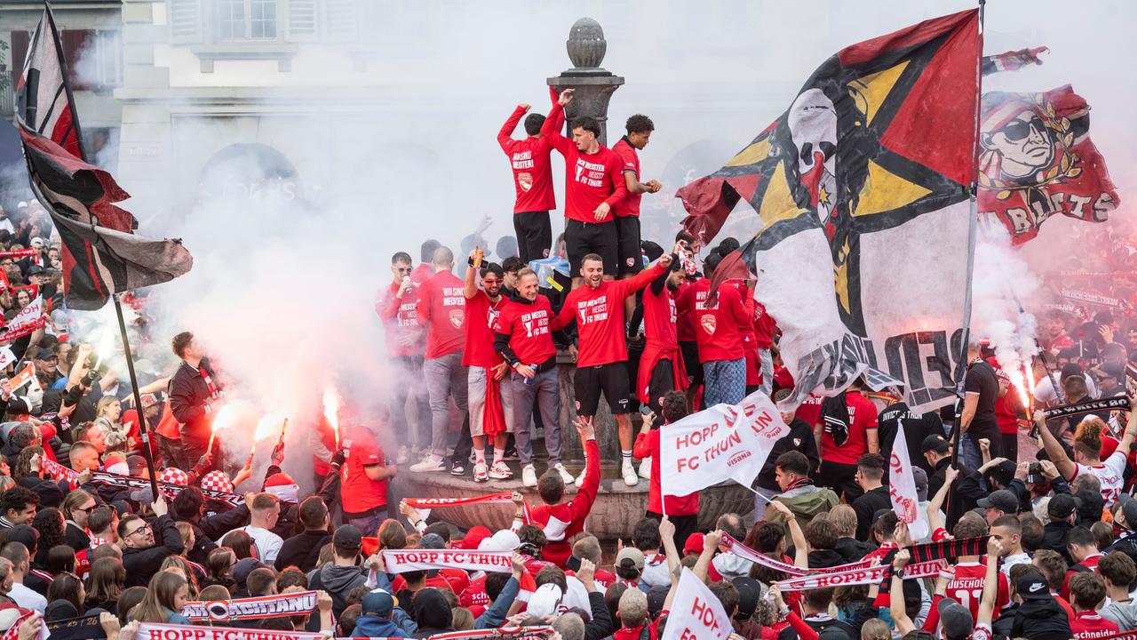 Fans des FC Thun feiern zusammen mit der Mannschaft, die auf einem Brunnen steht, die Schweizer Fußball-Meisterschaft. 