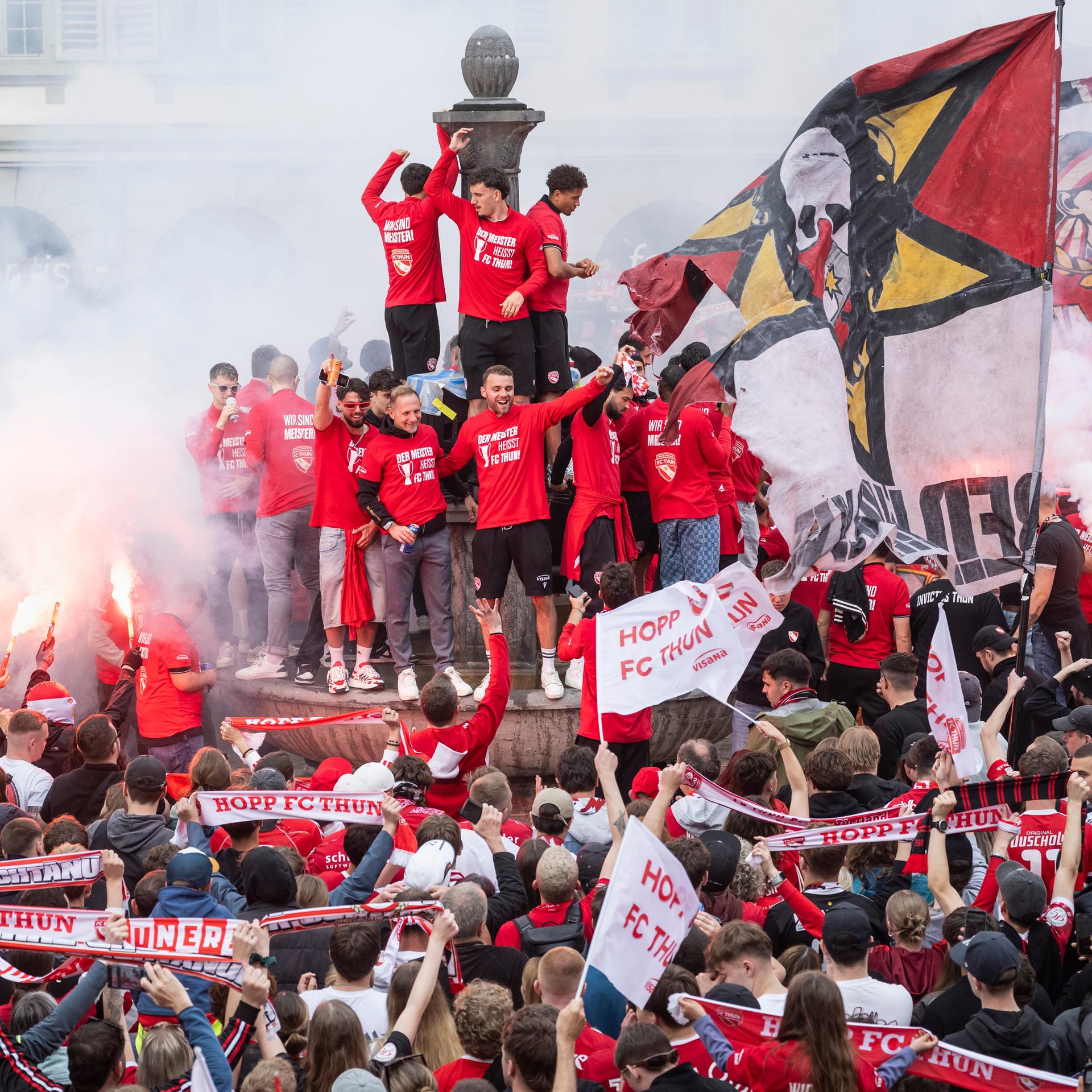 Fans des FC Thun feiern zusammen mit der Mannschaft, die auf einem Brunnen steht, die  Schweizer Fußball-Meisterschaft. 