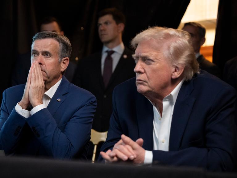 Donald Trump beobachtet mit grimmiger Mine an einem Tisch sitzend von Mar-a-Lago aus die Übertragung des Angriffs in Caracas.
