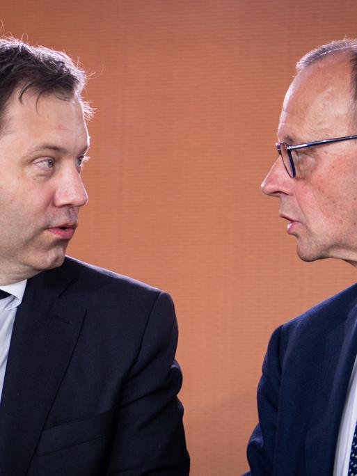 Bundeskanzler Friedrich Merz blickt zu Lars Klingbeil, Bundesminister der Finanzen. Sie sind im Gespräch. Sie sind im Profil zu sehen.