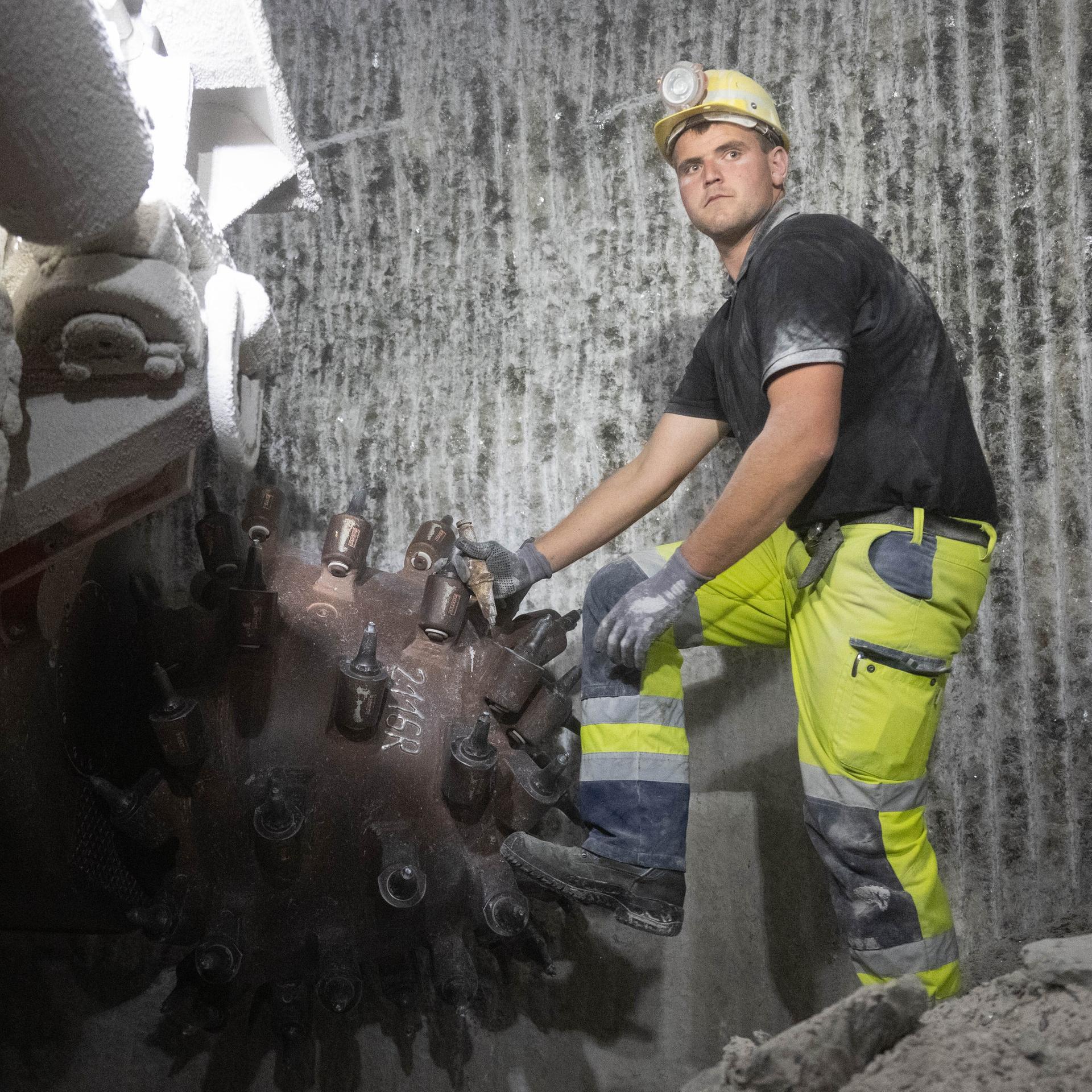 Ein Bergmann der Südwestdeutsche Salzwerke AG prüft etwa 200 Meter unter Tage im Bergwerk der Südwestdeutsche Salzwerke AG an einer Strecke, die für die SuedLink-Stromtrasse gelegt wird, an einer Teilschnittmaschine den Meißel. 