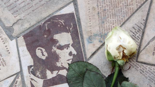 Porträt von Hans Scholl in der Gedenkstätte Weiße Rose an der Ludwig Maximilian Universität München. Ins Pflaster eingelassen, Flugblätter der Weißen Rose. 