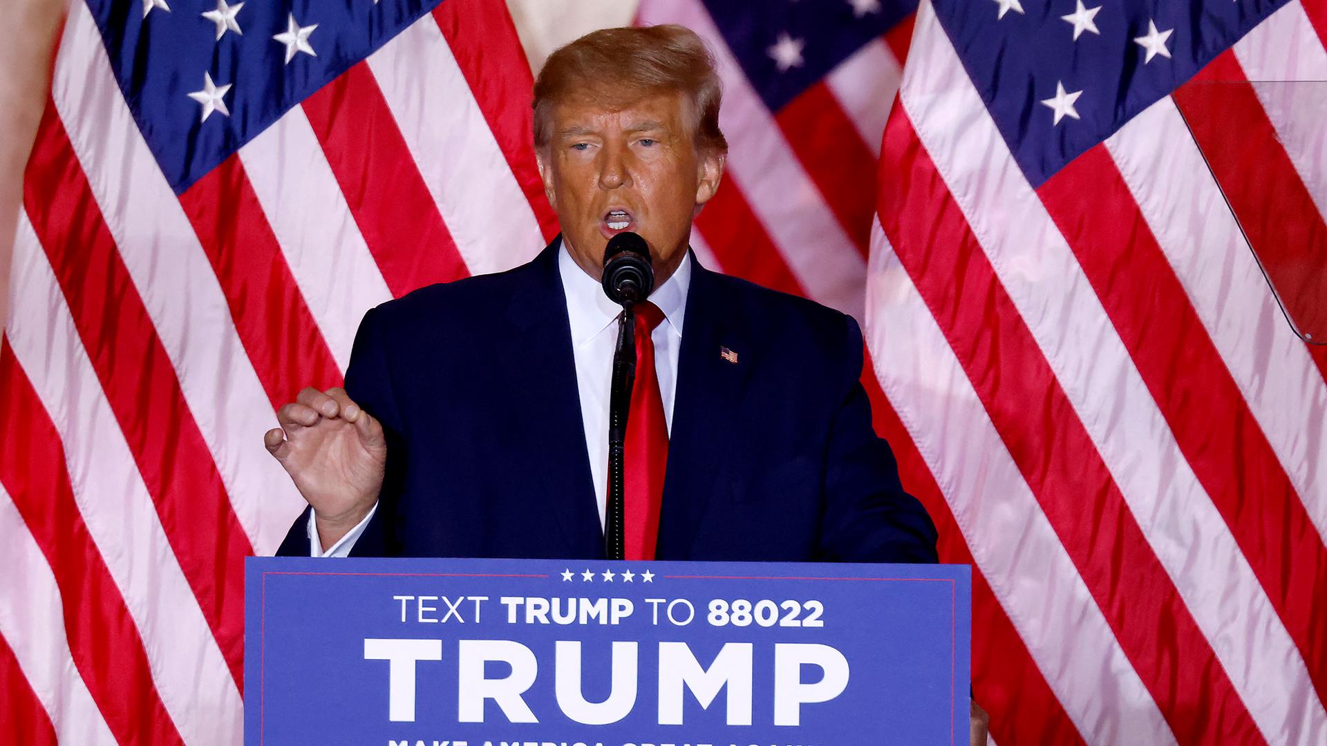 Donald Trump steht an einem Rednerpult, dahinter die US-Flagge.